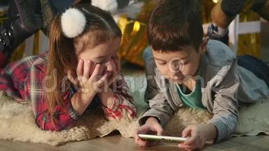 儿童在圣诞树附近<strong>玩手机</strong>、儿童和智能<strong>手机</strong>